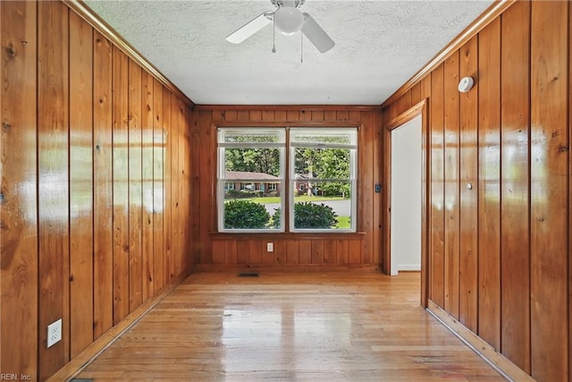 404 Forest Hill Cres, Suffolk, VA 23434 - spare room with light wood-type flooring, wood walls, a textured ceiling, ceiling fan, and baseboards