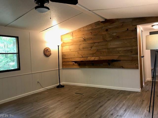 9917 Friendship Rd, North, VA 23128 - empty room featuring wood walls, wood finished floors, a ceiling fan, and baseboards