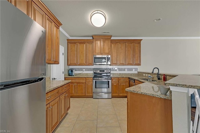 7556 Villa Ct, Gloucester, VA 23061 - kitchen with stainless steel appliances, a sink, ornamental molding, a peninsula, and brown cabinets