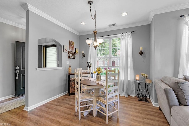 3101 Bridgewater Dr, Carrollton, VA 23314 - dining space featuring arched walkways, light wood finished floors, a chandelier, baseboards, and ornamental molding