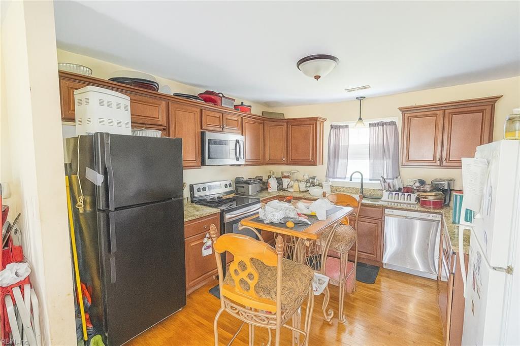 1400 Antoinette Cir, Hampton, VA 23663 - kitchen with stainless steel appliances, brown cabinetry, hanging light fixtures, and light wood-type flooring