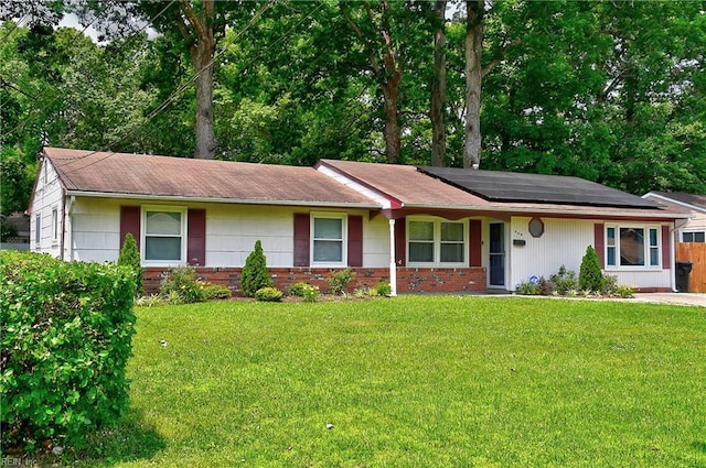 409 Barcelona Ln, Virginia Beach, VA 23452 - ranch-style house featuring roof mounted solar panels, a front lawn, brick siding, and roof with shingles