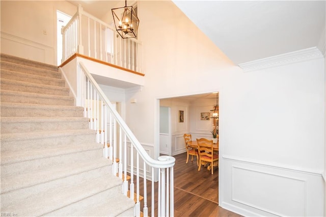 613 S Claypool Ct, Virginia Beach, VA 23464 - stairs with a chandelier, a decorative wall, wood finished floors, ornamental molding, and a high ceiling