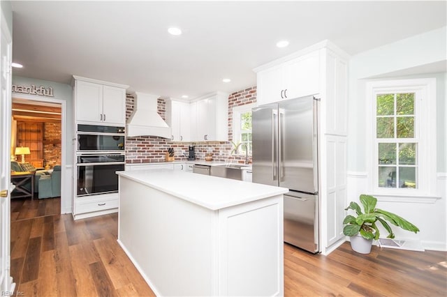 613 S Claypool Ct, Virginia Beach, VA 23464 - kitchen featuring stainless steel appliances, custom range hood, light countertops, wood finished floors, and recessed lighting
