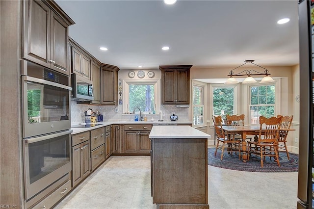 1204 Merrifield Lndg, Virginia Beach, VA 23464 - kitchen featuring appliances with stainless steel finishes, decorative backsplash, light countertops, a sink, and dark brown cabinetry