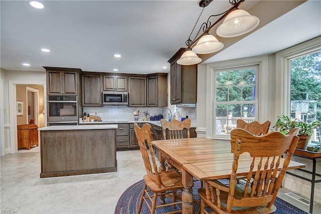 1204 Merrifield Lndg, Virginia Beach, VA 23464 - kitchen featuring stainless steel appliances, dark brown cabinetry, light countertops, a kitchen island, and backsplash