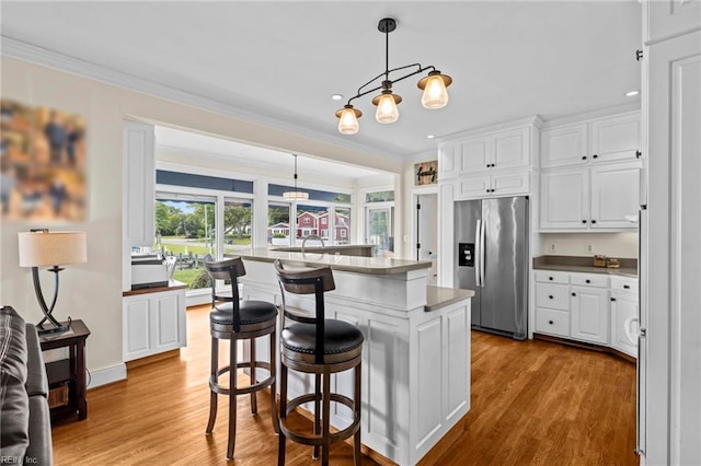 200 Congress Ave, Hampton, VA 23669 - kitchen with stainless steel fridge, ornamental molding, white cabinets, wood finished floors, and a kitchen island with sink