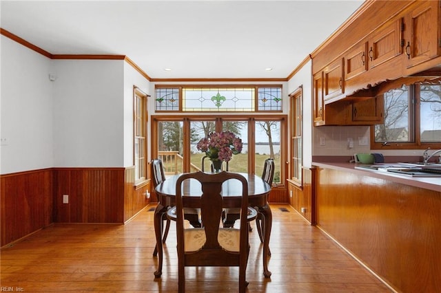 2543 Bridge Rd, Suffolk, VA 23435 - dining area featuring healthy amount of natural light, crown molding, light wood finished floors, a wainscoted wall, and wood walls