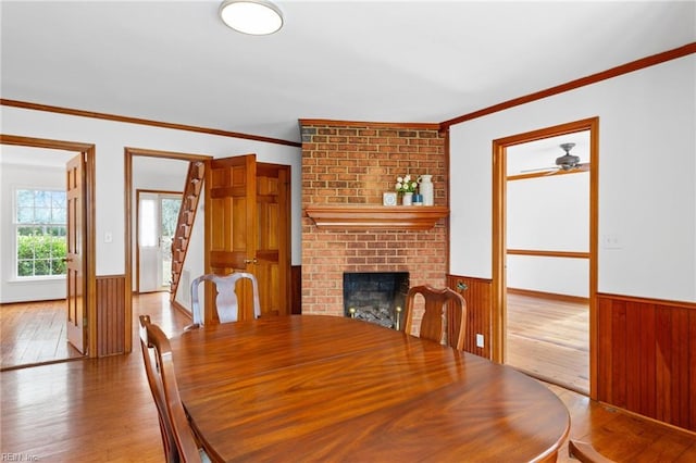 2543 Bridge Rd, Suffolk, VA 23435 - dining room featuring a wainscoted wall, hardwood / wood-style flooring, a fireplace, stairs, and wooden walls