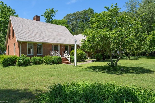 2543 Bridge Rd, Suffolk, VA 23435 - view of front facade with a chimney, a front lawn, brick siding, and a shingled roof