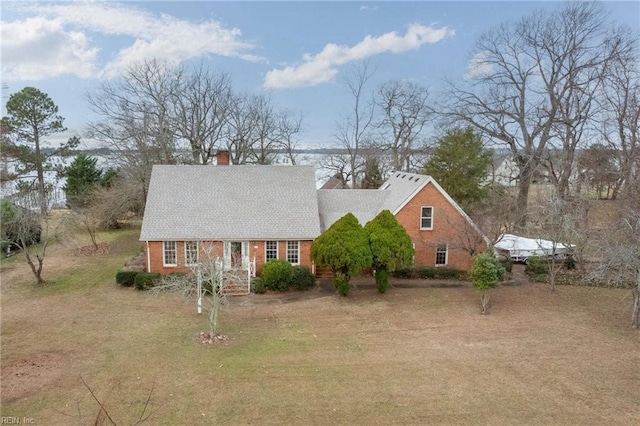 2543 Bridge Rd, Suffolk, VA 23435 - new england style home featuring a chimney, brick siding, and a front lawn