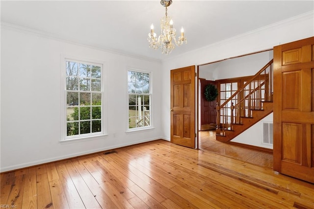 2543 Bridge Rd, Suffolk, VA 23435 - spare room with a chandelier, stairway, ornamental molding, baseboards, and light wood-type flooring