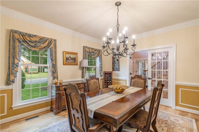 3512 Quail Holw, Williamsburg, VA 23185 - dining area featuring a chandelier, ornamental molding, light wood-style flooring, plenty of natural light, and a wainscoted wall