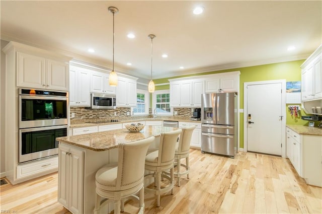 3512 Quail Holw, Williamsburg, VA 23185 - kitchen featuring stainless steel appliances, decorative backsplash, white cabinetry, a kitchen island, and crown molding