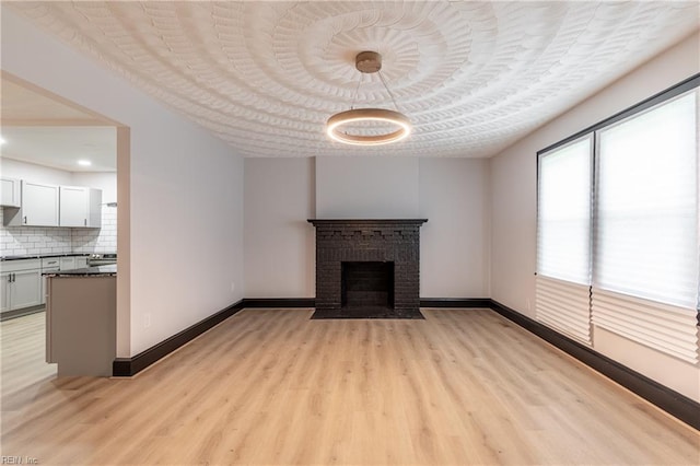 1943 Sycamore Ln, Norfolk, VA 23523 - unfurnished living room featuring light wood-type flooring, baseboards, and a brick fireplace