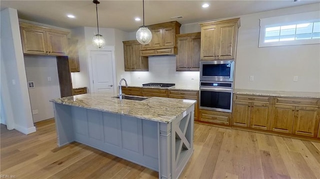 100 Creek Ln, Suffolk, VA 23435 - kitchen with stainless steel appliances, a sink, brown cabinetry, light wood-style floors, and light stone countertops