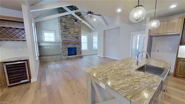 100 Creek Ln, Suffolk, VA 23435 - kitchen featuring wine cooler, a sink, ceiling fan, a stone fireplace, and light wood-style floors