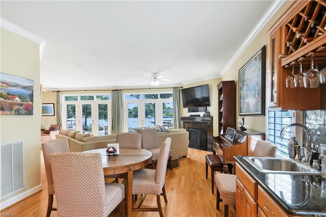 2637 Broad Bay Rd, Virginia Beach, VA 23451 - dining area featuring ornamental molding, ceiling fan, a fireplace, light wood-type flooring, and french doors