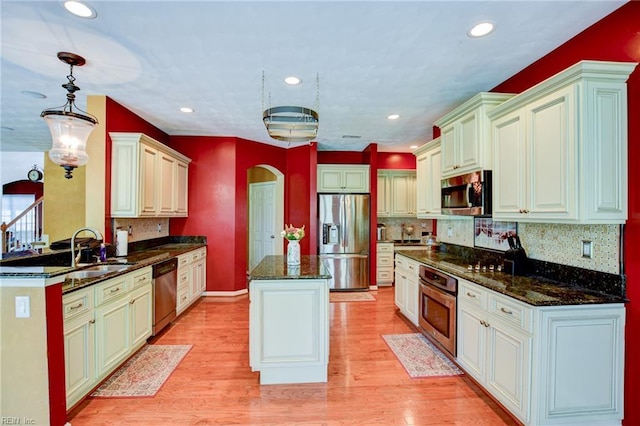 313 Queen Ct, Smithfield, VA 23430 - kitchen with stainless steel appliances, a sink, arched walkways, a center island, and decorative backsplash