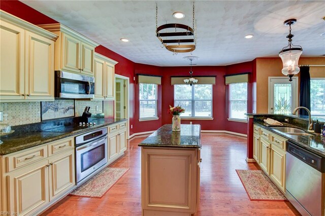 313 Queen Ct, Smithfield, VA 23430 - kitchen featuring cream cabinets, appliances with stainless steel finishes, a sink, a center island, and baseboards