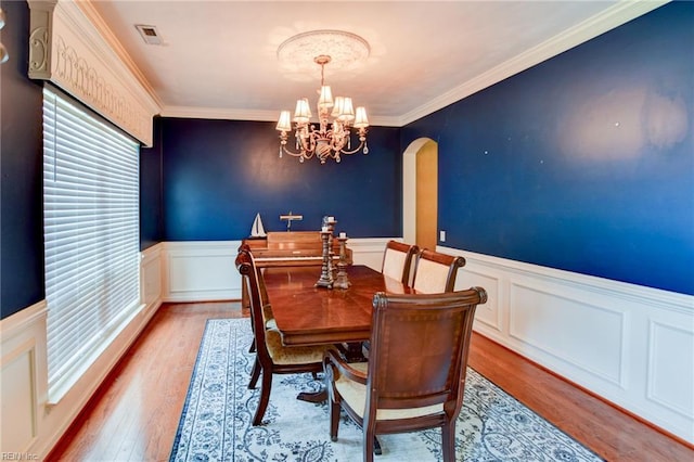 313 Queen Ct, Smithfield, VA 23430 - dining area featuring wainscoting, a chandelier, wood finished floors, ornamental molding, and a decorative wall