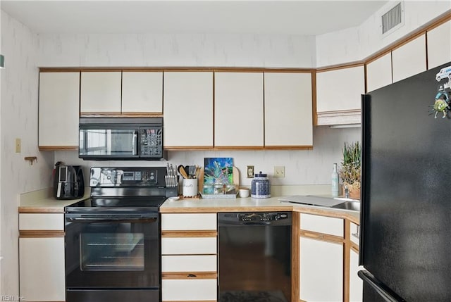 612 Shoreham Ct Unit 202, Virginia Beach, VA 23451 - kitchen with black appliances, light countertops, and white cabinets
