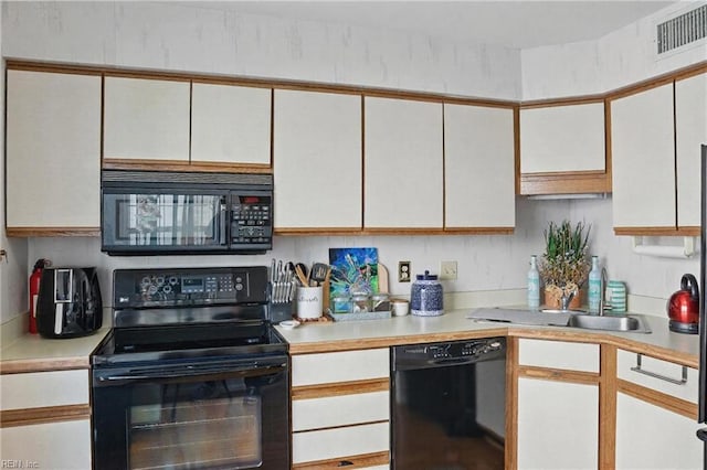 612 Shoreham Ct Unit 202, Virginia Beach, VA 23451 - kitchen featuring black appliances, light countertops, a sink, and white cabinetry