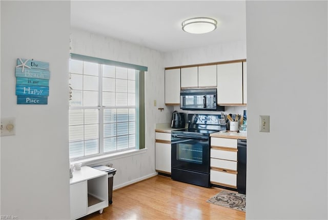 612 Shoreham Ct Unit 202, Virginia Beach, VA 23451 - kitchen featuring black appliances, light wood-type flooring, light countertops, and white cabinets
