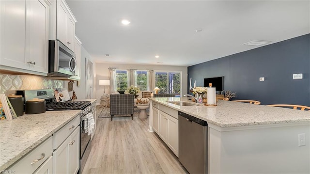 1228 Kidbrooke St, Chesapeake, VA 23322 - kitchen featuring appliances with stainless steel finishes, a sink, open floor plan, backsplash, and white cabinetry