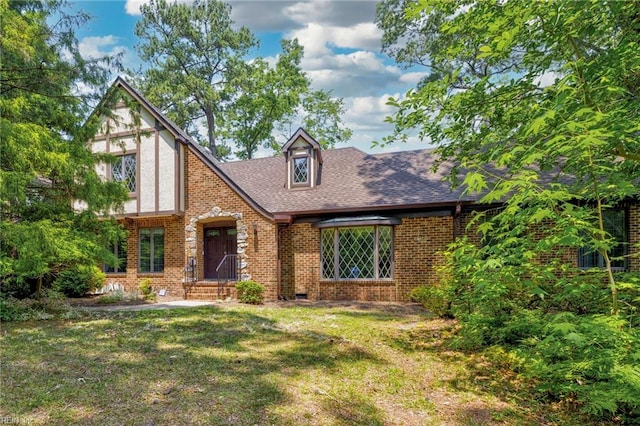 9 Hill Way, Carrollton, VA 23314 - english style home with brick siding, a front lawn, and a shingled roof
