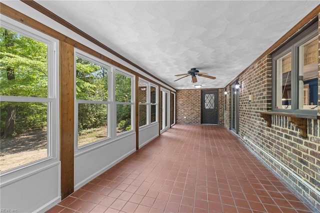 9 Hill Way, Carrollton, VA 23314 - unfurnished sunroom featuring brick wall, a ceiling fan, and ornamental molding