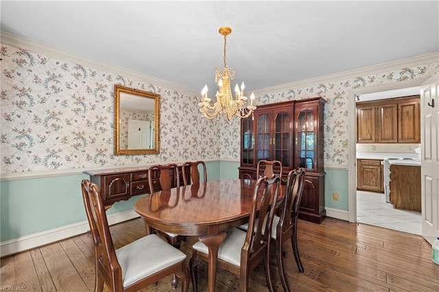 9 Hill Way, Carrollton, VA 23314 - dining area with wainscoting, wood-type flooring, a chandelier, wallpapered walls, and ornamental molding