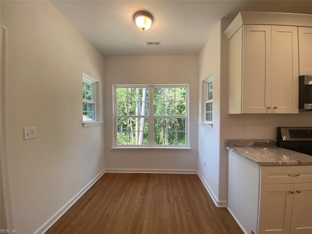 7228 Gates Rd, Suffolk, VA 23437 - kitchen featuring dark wood-type flooring, stainless steel stove, white cabinetry, and baseboards