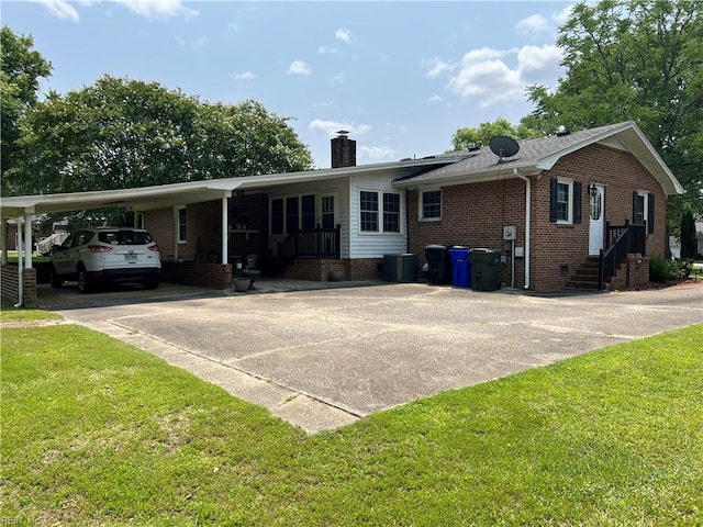 432 Crescent Dr, Franklin, VA 23851 - back of property featuring driveway, a chimney, brick siding, and a yard