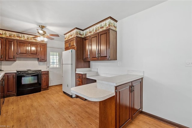 3435 Macdonald Rd, Virginia Beach, VA 23464 - kitchen with black range with electric stovetop, freestanding refrigerator, a peninsula, ceiling fan, and light wood finished floors