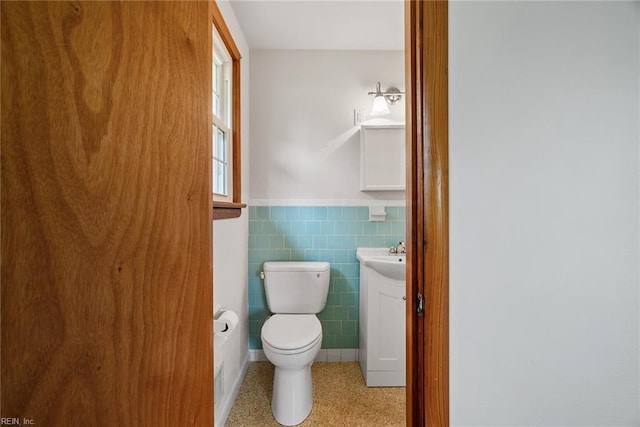3435 Macdonald Rd, Virginia Beach, VA 23464 - half bathroom featuring tile walls, a wainscoted wall, toilet, and vanity