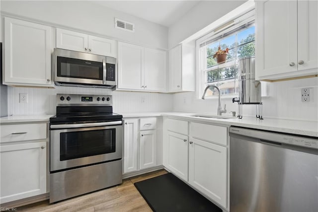 882 Elizabeth Ct, Virginia Beach, VA 23451 - kitchen with appliances with stainless steel finishes, a sink, white cabinetry, and light countertops