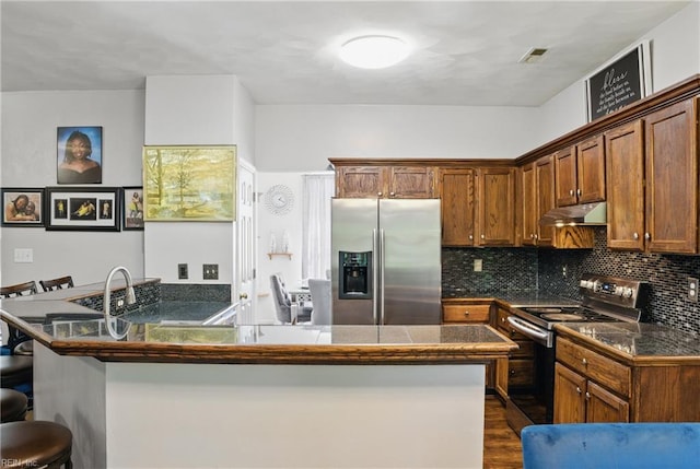 127 Rockland Ter, Suffolk, VA 23434 - kitchen with stainless steel fridge, electric range oven, under cabinet range hood, a kitchen breakfast bar, and a peninsula