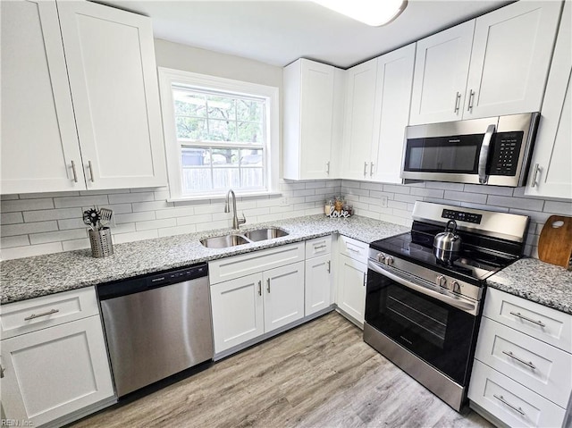 865 Kings Arms Dr, Virginia Beach, VA 23452 - kitchen with stainless steel appliances, a sink, white cabinets, light wood-style flooring, and light stone countertops