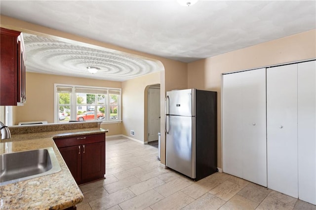 2811 Mapleton Ave, Norfolk, VA 23504 - kitchen featuring freestanding refrigerator, a sink, arched walkways, baseboards, and a peninsula