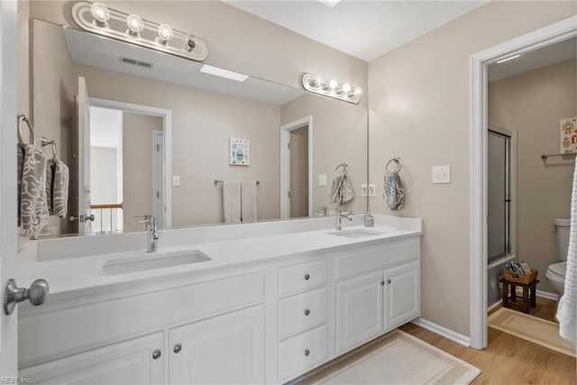 6 Lessies Dr, Poquoson, VA 23662 - full bathroom with wood finished floors, double vanity, a shower with shower door, and toilet