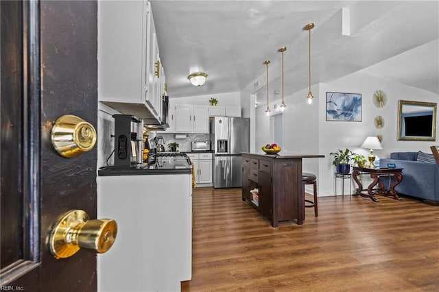 1208 Santeetlah Ave, Chesapeake, VA 23325 - kitchen with stainless steel fridge, dark countertops, dark wood-style flooring, a kitchen bar, and white cabinetry