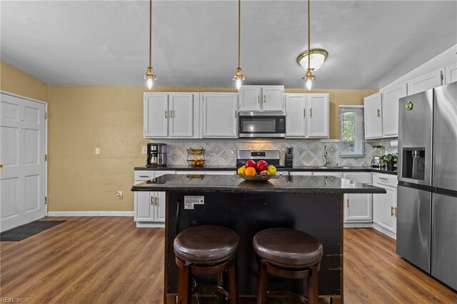 1208 Santeetlah Ave, Chesapeake, VA 23325 - kitchen with stainless steel appliances, a kitchen breakfast bar, backsplash, white cabinets, and a kitchen island