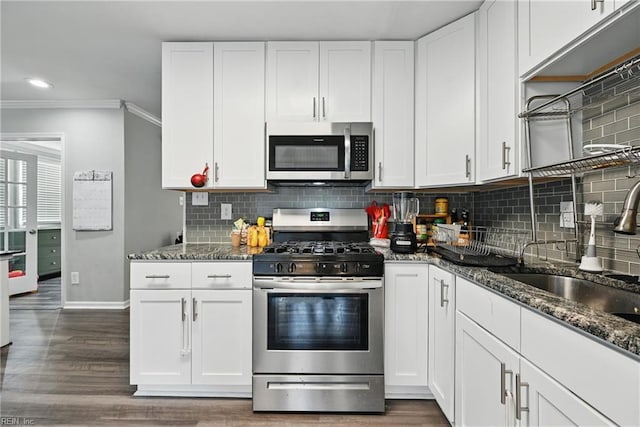 619 City Park Ave, Portsmouth, VA 23701 - kitchen featuring stainless steel appliances, crown molding, a sink, white cabinetry, and dark stone countertops