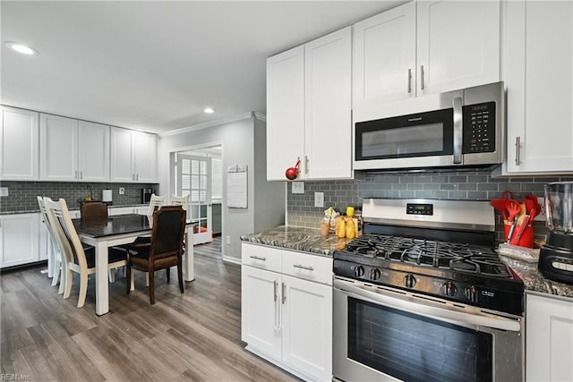 619 City Park Ave, Portsmouth, VA 23701 - kitchen featuring appliances with stainless steel finishes, white cabinetry, tasteful backsplash, ornamental molding, and wood finished floors