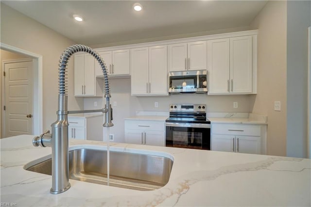 515 Buckroe Ave, Hampton, VA 23664 - kitchen featuring stainless steel appliances, a sink, white cabinetry, light stone counters, and recessed lighting