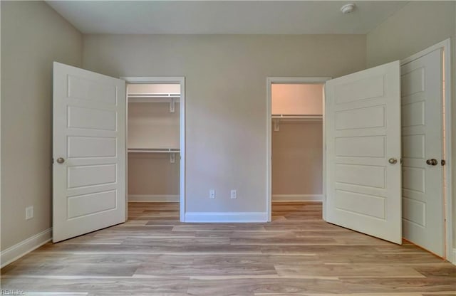 515 Buckroe Ave, Hampton, VA 23664 - unfurnished bedroom with light wood-style flooring, baseboards, and a walk in closet