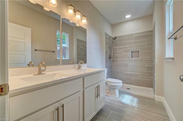 515 Buckroe Ave, Hampton, VA 23664 - bathroom featuring double vanity, toilet, a tile shower, and baseboards