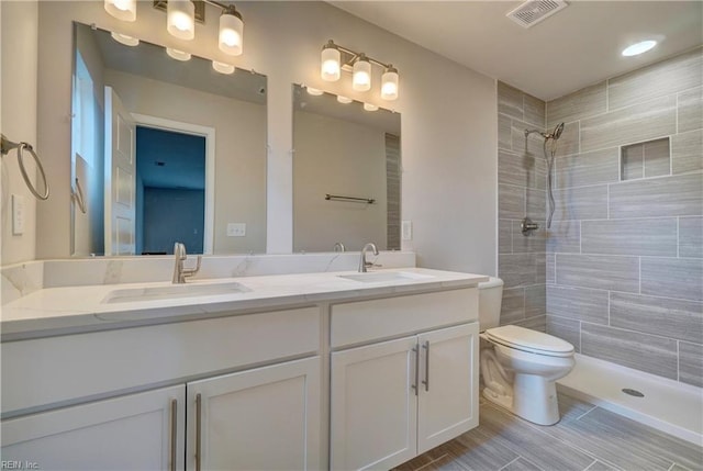 515 Buckroe Ave, Hampton, VA 23664 - bathroom featuring double vanity, tiled shower, and toilet