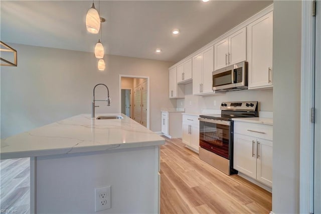 515 Buckroe Ave, Hampton, VA 23664 - kitchen with stainless steel appliances, a sink, light wood finished floors, white cabinetry, and recessed lighting